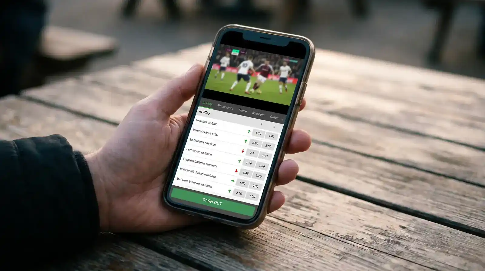 Smartphone in portrait mode showing a live-streamed Championship football match with the in-play betting markets and cash-out button below the video player