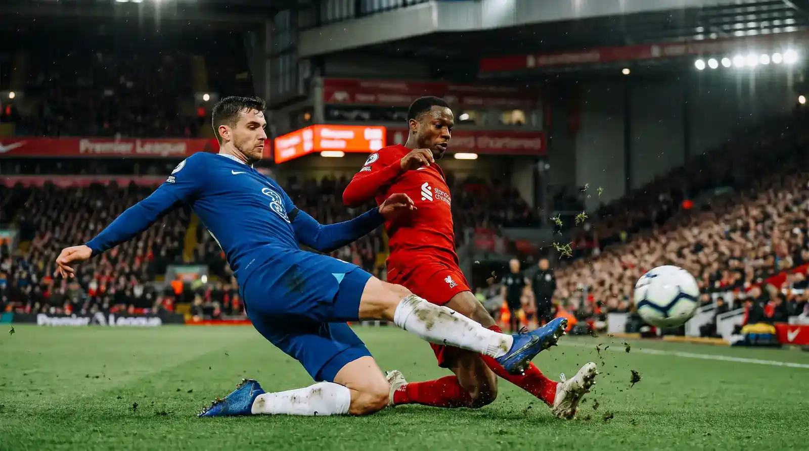Full-back making a sliding tackle near the touchline during a Premier League defensive sequence
